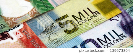 Costa Rican colon money bills pile on table. Costa Rica banknotes of CRC currency close up Costa Rican colon money bills pile on table. Costa Rica banknotes of CRC currency close up 139673804