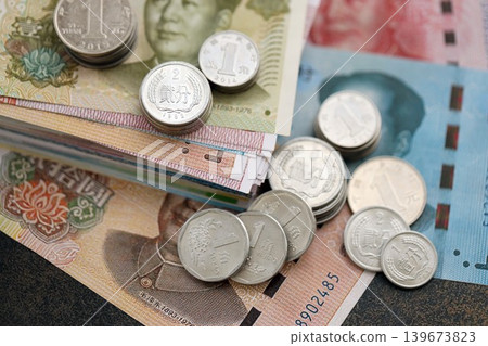 Chinese yuan money bills and jiao coins pile on table. China coins on banknotes of CNY currency Chinese yuan money bills and jiao coins pile on table. China coins on banknotes of CNY currency 139673823