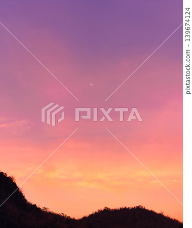 Colorful sky with crescent moon and star over mountain 139674124