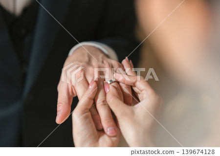 Romantic moment of a bridge and groom exchanging diamond rings during wedding ceremony Romantic moment of a bridge and groom exchanging diamond rings during wedding ceremony 139674128