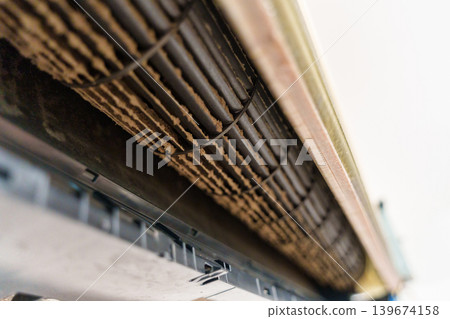Remove and cleaning dirty air conditioner with dust covered fan blades and coils 139674158