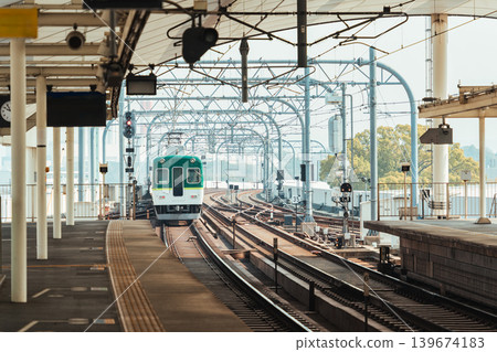 Electric railway train with metal structure and tracks arrival to station at Kyoto Electric railway train with metal structure and tracks arrival to station at Kyoto 139674183