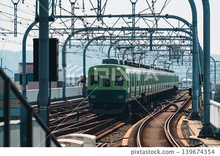 Electric railway train with metal structure and tracks arrival to station at Kyoto 139674354