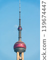 Closeup of Oriental Pearl TV Tower with pink spheres and antenna against blue sky 139674447