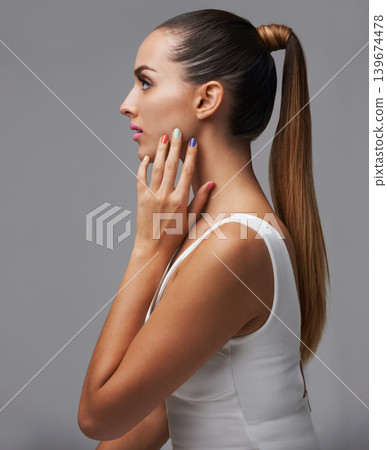 Woman, profile and hand with makeup and manicure, nail polish and cosmetic care for skin on grey background. Confidence, beauty with glow lipstick and rainbow color nails for glamour in studio Woman, profile and hand with makeup and manicure, nail polish and cosmetic care for skin on grey background. Confidence, beauty with glow lipstick and rainbow color nails for glamour in studio 139674478