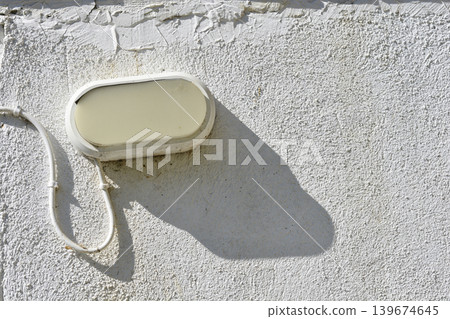 Outdoor oval bulkhead light on a white textured wall Outdoor oval bulkhead light on a white textured wall 139674645