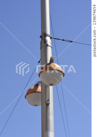 Street Lanterns on a Metal Pole Against Blue Sky 139674654