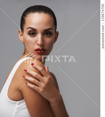 Makeup, woman in portrait for beauty and manicure in studio, nail polish and lashes with skin and cosmetics on grey background. Red lipstick, nails and glamour, mascara for confidence and elegance Makeup, woman in portrait for beauty and manicure in studio, nail polish and lashes with skin and cosmetics on grey background. Red lipstick, nails and glamour, mascara for confidence and elegance 139674700