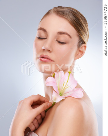 Eyes closed, beauty and woman with skincare, flowers and wellness on a white studio background. Person, model or girl with natural cosmetics or healthy skin with shine, relax or glow with dermatology 139674729