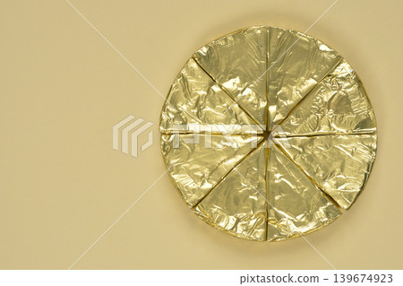 Golden Foil Cheese Triangles on Beige Background 139674923