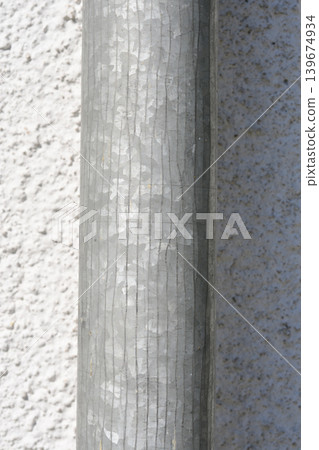 Vertical close up of a galvanized metal downspout against a white wall Vertical close up of a galvanized metal downspout against a white wall 139674934