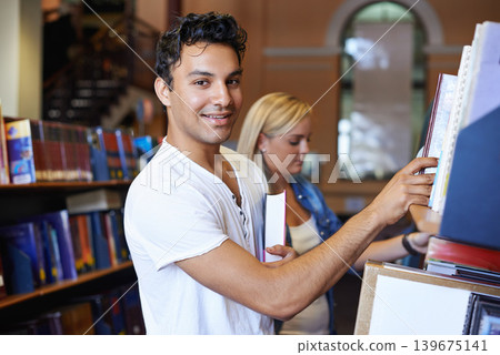 Portrait, book or student in a library to search at university, college or school campus for education. Bookshelf, learning or happy man with scholarship studying knowledge, research and information 139675141