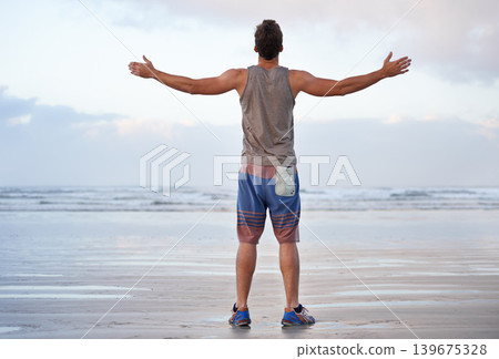 Back, arms raised and man with vacation, journey and travel with summer break and tropical island getaway. Person, seaside and guy with freedom or fitness with wellness, adventure and morning routine 139675328