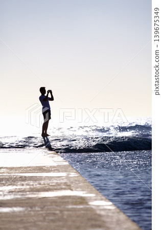 Silhouette, waves and ocean, man and photography with phone on holiday and travel in Miami, mockup space and summer. Adventure, content creator or influencer with picture for blog and sea view Silhouette, waves and ocean, man and photography with phone on holiday and travel in Miami, mockup space and summer. Adventure, content creator or influencer with picture for blog and sea view 139675349
