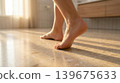 Bare feet walking across a heated light beige terrazzo bathroom floor 139675633