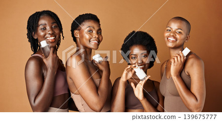 Happy black woman, skincare and cosmetics for beauty, tone or foundation against a brown studio background. Group portrait of African female people or model smile together with skin makeup on mockup Happy black woman, skincare and cosmetics for beauty, tone or foundation against a brown studio background. Group portrait of African female people or model smile together with skin makeup on mockup 139675777
