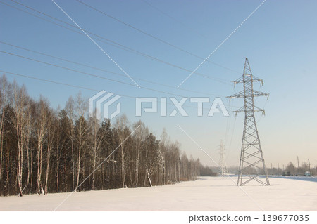 High voltage power line tower in snowy winter landscape High voltage power line tower in snowy winter landscape 139677035