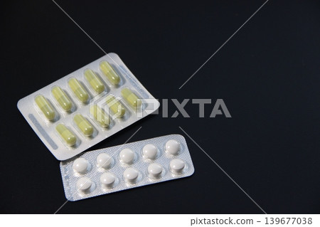 Pharmaceutical pills and capsules in blister pack on dark background Pharmaceutical pills and capsules in blister pack on dark background 139677038