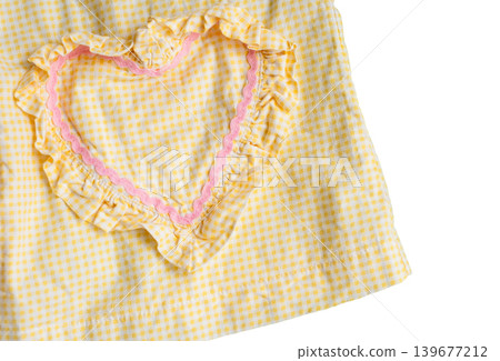 Yellow checkered fabric with pink heart-shaped ruffle pattern on white background Yellow checkered fabric with pink heart-shaped ruffle pattern on white background 139677212