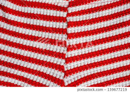 Close-up of red and white striped knitted fabric Close-up of red and white striped knitted fabric 139677219