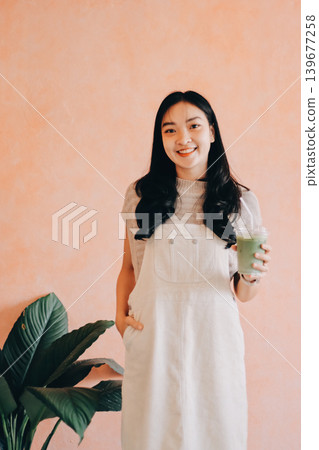 Young woman drinking iced coffee outside a chocolate shop 139677258