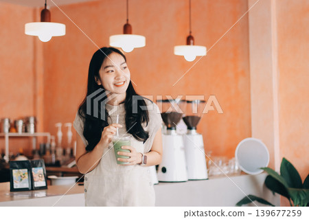 Young woman drinking iced coffee outside a chocolate shop 139677259