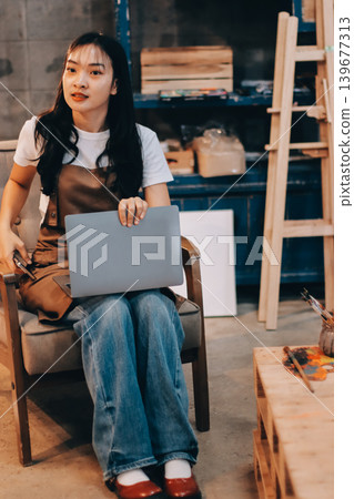 Female artist wears black hat posing near picture indoor the studio Female artist wears black hat posing near picture indoor the studio 139677313