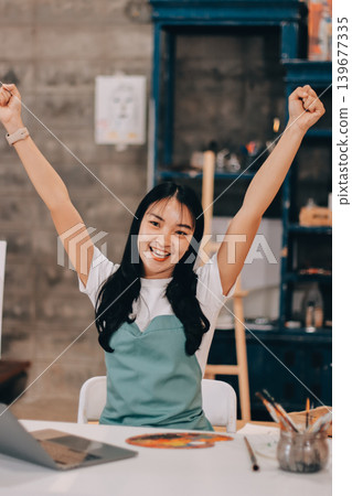 Female artist wears black hat posing near picture indoor the studio Female artist wears black hat posing near picture indoor the studio 139677335