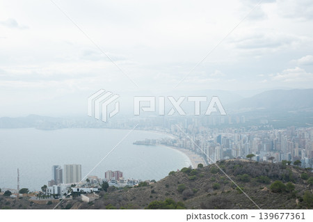 Overcast benidorm coastal cityscape with cloudy sky and rolling hills Overcast benidorm coastal cityscape with cloudy sky and rolling hills 139677361