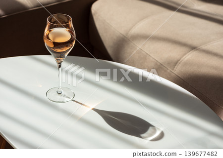 Rose Wine Glass with Shadows on White Table 139677482
