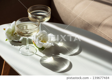 Champagne Glasses with Flowers under Sunlight. Champagne Glasses with Flowers under Sunlight. 139677484