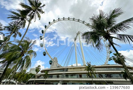 The giant Singapore Flyer Ferris wheel against a bright blue sky in the Marina Bay area, an iconic landmark The giant Singapore Flyer Ferris wheel against a bright blue sky in the Marina Bay area, an iconic landmark 139677680