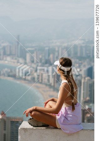 Woman enjoying scenic coastal city view from high vantage point Woman enjoying scenic coastal city view from high vantage point 139677726