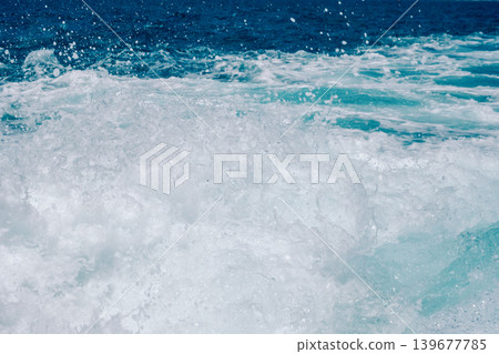 Ocean waves crashing with white foam against deep blue sea horizon 139677785
