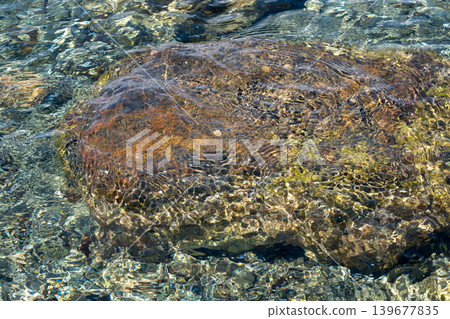 Sunlit rock beneath crystal clear water in pristine natural creek setting Sunlit rock beneath crystal clear water in pristine natural creek setting 139677835