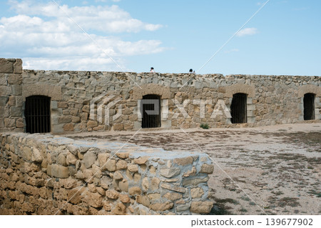 Old stone fortress wall with blue sky and white clouds Old stone fortress wall with blue sky and white clouds 139677902