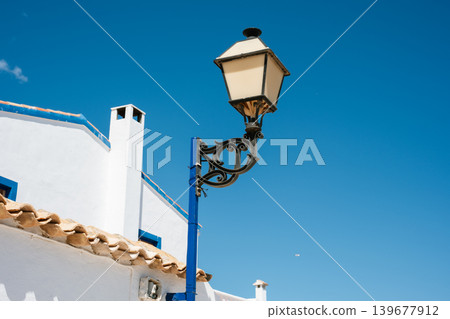 Mediterranean streetlight against clear blue sky in traditional white village setting Mediterranean streetlight against clear blue sky in traditional white village setting 139677912