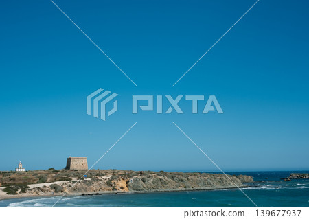 Sunny coastal landscape with historic tower and clear blue sky 139677937