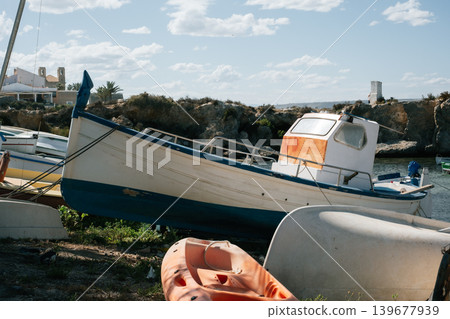 Beached fishing boat on rocky shore with life rafts and ocean view in sunny weather 139677939