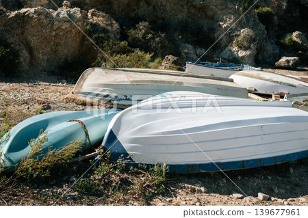 Abandoned rowboats on rocky shore: serene coastal landscape and rustic charm Abandoned rowboats on rocky shore: serene coastal landscape and rustic charm 139677961
