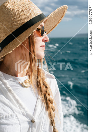 Woman in straw hat enjoying ocean breeze on sunny day 139677974