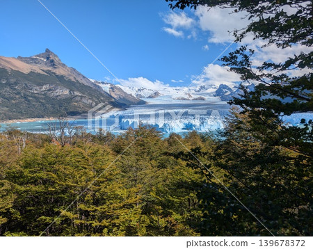 Perito Moreno Glacier in Patagonia at the foot of the Andes. Blue icebergs float in the water at the foot of the enormous ice walls of the Patagonian mountain glacier in Argentina. Perito Moreno Glacier in Patagonia at the foot of the Andes. Blue icebergs float in the water at the foot of the enormous ice walls of the Patagonian mountain glacier in Argentina. 139678372