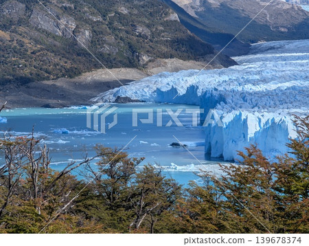 Perito Moreno Glacier in Patagonia, at the foot of the snow-capped Andes. Blue icebergs float in the water of a glacial lake. 139678374