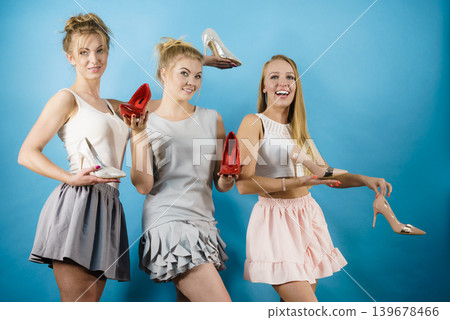 Three women showing high heels shoes Three women showing high heels shoes 139678466