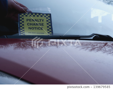 Driver finds parking ticket on windshield of car Driver finds parking ticket on windshield of car 139679585