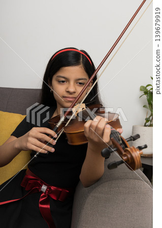 A young girl is playing the violin A young girl is playing the violin 139679919