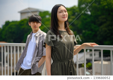 一張年輕男子和女子站在戶外的照片。 139680052