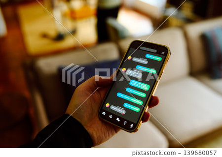 我坐在沙發上,用智慧型手機查看聊天記錄。 我坐在沙發上,用智慧型手機查看聊天記錄。 139680057
