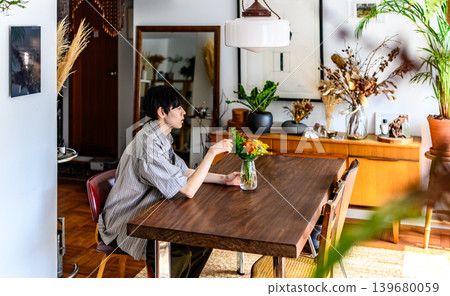 一位年輕男子在餐廳裡欣賞鮮花。 139680059