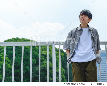 一個年輕人站在屋頂上仰望天空 139680067